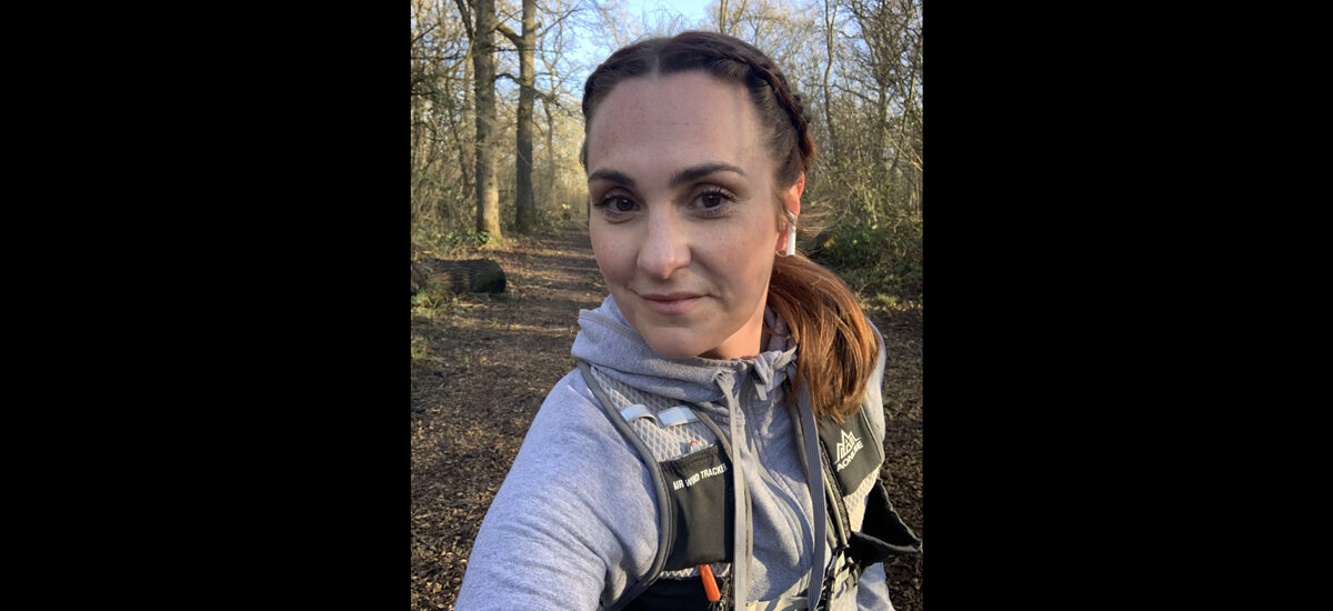 Sadie Oleary, Nursing Associate FdSc student. Sadie is in a forest area , wearing running gear.