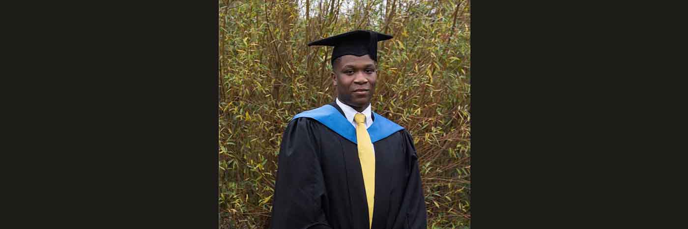 Graduate Daniel Maloney is pictured on his graduation day wearing graduation robes and a mortarboard smiling at the camera