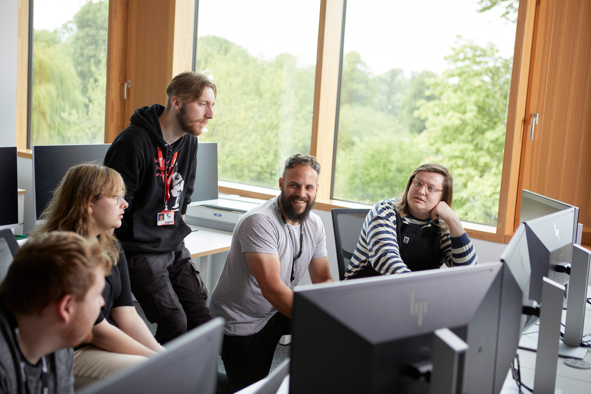 Academic and four students working on desktops