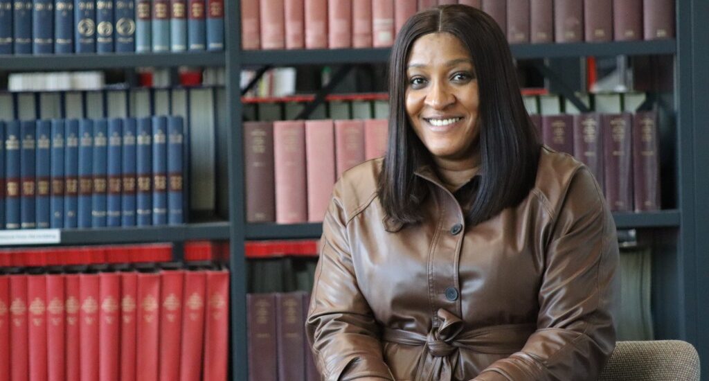 Image of Maureen Chinwe Ilonuba, an MBA student at UON sat in a library.