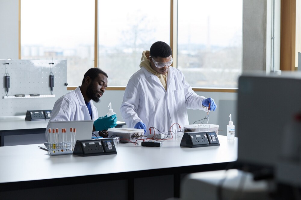 Two students in lab coats undertaking an experiment in a laboratory